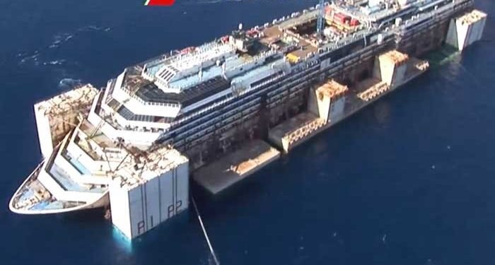 Costa Concordia wreckage under tow for ditching image description