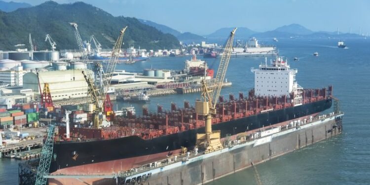 A large tanker ship is being renovated in shipyard