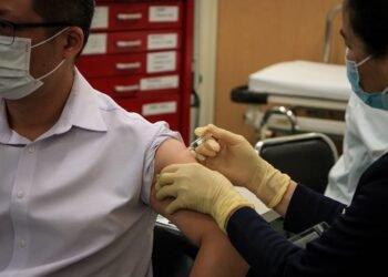 Man being vaccinated against Covid-19, Macau, China