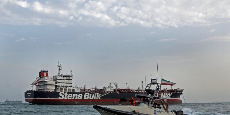 A boat of Iranian Revolutionary Guard sails next to Stena Impero, a British-flagged vessel owned by Stena Bulk, at Bandar Abbas port