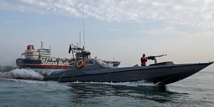 A boat of the Iranian Revolutionary Guard sails next to Stena Impero at Bandar Abbas port