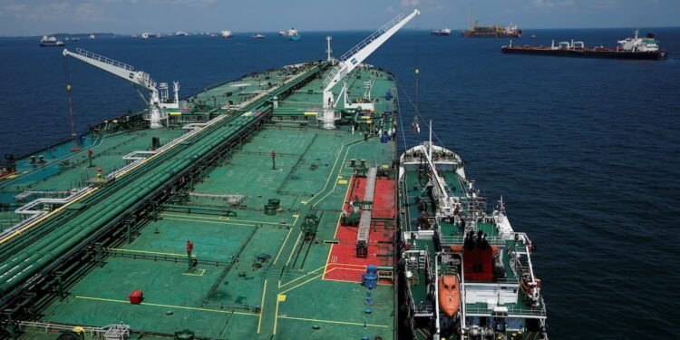 A bunker vessel prepares to supply fuel to Hin Leong's Pu Tuo Shan VLCC supertanker in the waters off Jurong Island in Singapore