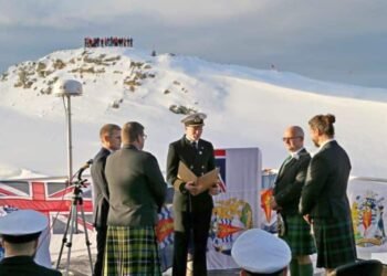 Ship Captain Will Whatley reads the nuptials to Eric (left) and Steve, with staff from Rothera Research Station in the background.