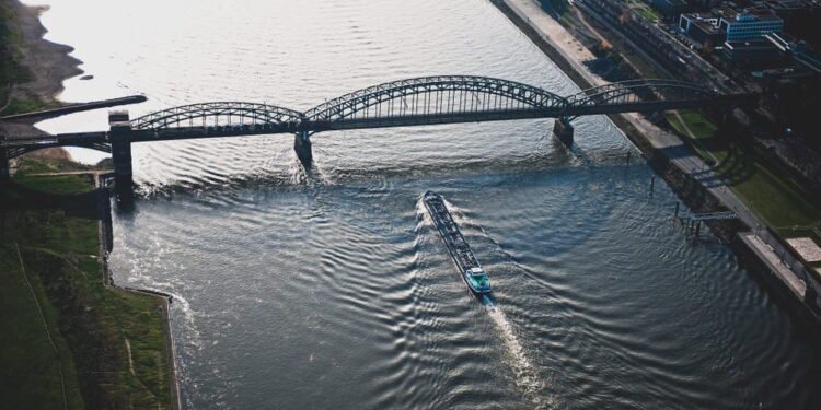 a ship passes below a bridge on the Rhine River