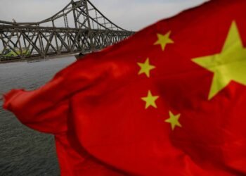 A Chinese flag is seen in front of the Friendship bridge over the Yalu River connecting the North Korean town of Sinuiju and Dandong in China