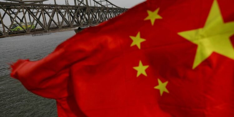 A Chinese flag is seen in front of the Friendship bridge over the Yalu River connecting the North Korean town of Sinuiju and Dandong in China