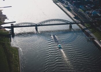 a ship passes below a bridge on the Rhine River