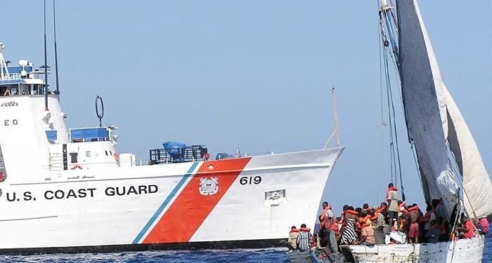 maritime border enforcement scene showing USCG cutter stopping overloaded boat