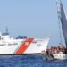 maritime border enforcement scene showing USCG cutter stopping overloaded boat