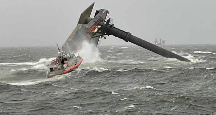 Capsized SEACOR Power on the evening of the accident, with a Coast Guard response boat in the foreground. [U.S. Coast Guard photograph]